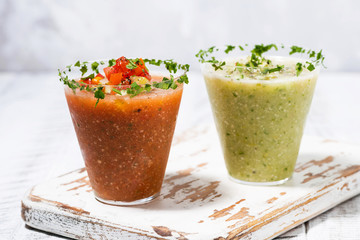 fresh cold soups. red and green gazpacho in glasses on white table