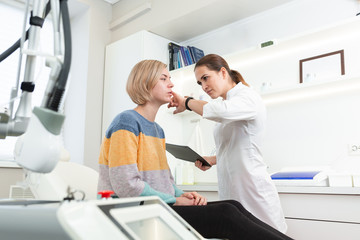 Obraz premium Professional woman cosmetologist in beauty clinic consulting young female client. Skin Care concept