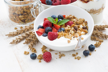 healthy breakfast with natural yogurt, muesli and fresh berries on white wooden background