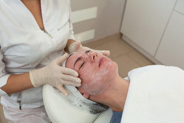 Healing Care Cream after Laser rejuvenating facial face treatment at cosmetology clinic. Young...