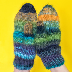 Pair of varicolored striped mittens isolate on white.