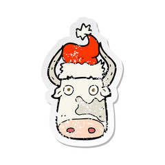 retro distressed sticker of a cartoon cow wearing christmas hat