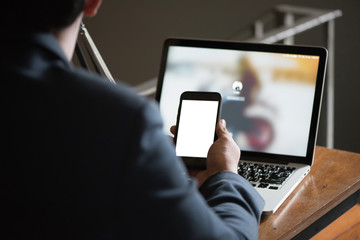 Asian business man working with his smartphone in coffee shop in selective focus.