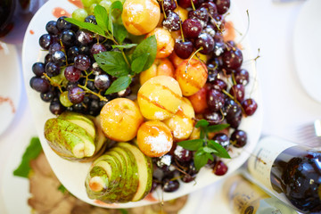 tasty fruit on a plate with pears, grapes, apricots