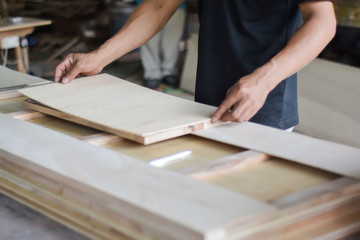 Hand of carpenter working with furniture wood.