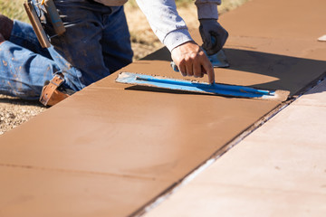 Construction Worker Smoothing Wet Cement With Trowel Tools
