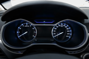 Close-up of a glowing beautiful dashboard of a modern expensive car. The interior of the car. The foreground is blurred