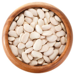 Dried lima beans in a wooden bowl. View from above. Isolated on white background.