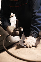 Close up of blacksmith grindering a metal plate