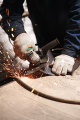 Close up of blacksmith grindering a metal plate