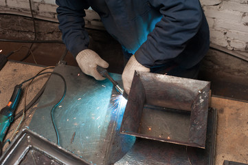 Blacksmith soldering a metal stand