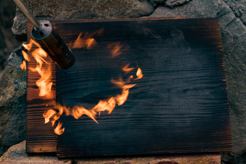 fire flame on black board wood texture, and gas torch