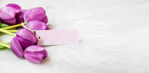 Spring tulips bouquet with card label , women's or mother's day holiday greeting with copy space label card, beautiful spring holidays card with purple tulips