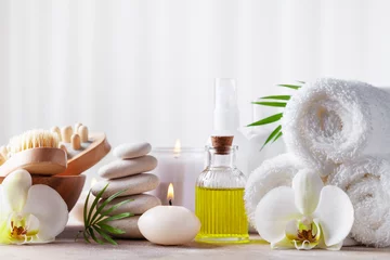 Poster Spa, schoonheidsbehandeling en wellness-achtergrond met massagekiezelstenen, orchideebloemen, handdoeken, cosmetische producten en brandende kaarsen. © juliasudnitskaya