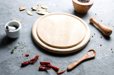 Cutting board and spices on a gray background.