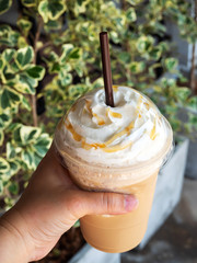 Cappuccino blended in plastic cup. Served with whipped cream. Refreshment drink. Favorite caffeine...