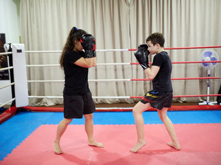 Fototapeta na wymiar Boy and girl kickboxers in the ring
