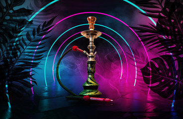 Hookah on the background of tropical leaves and a brick wall. Neon light, laser figures in smoke