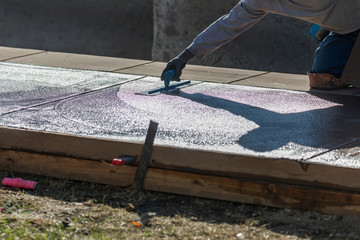 Construction Worker Smoothing Wet Cement With Trowel Tools