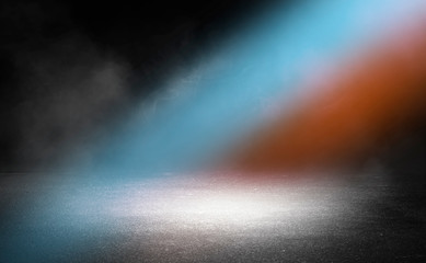 Dark empty stage, blue and orange neon spotlight, wet asphalt, smoke, night shooting, rays