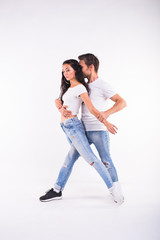Young couple dancing social dance bachata, merengue, salsa, kizomba. Two elegance pose on white room.