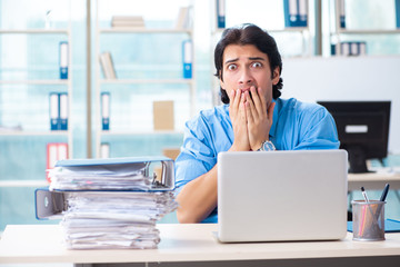 Handsome businessman unhappy with excessive work in the office 