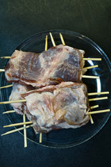Raw portioned meat on skewers overhead