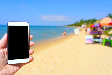 men using phone on beach