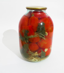Marinated tomatoes in a jar on a white background.