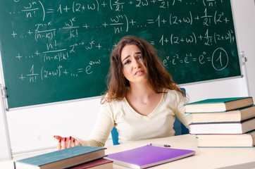 Young female math teacher in front of chalkboard  