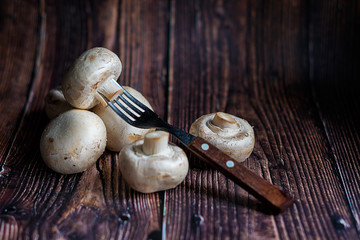 Fresh Mushrooms on wooden background with fork