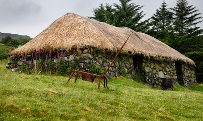 Colbost Croft Museum Blackhouse with stone walls and rocks holding netting for thatched roof Isle of Skye Scotland UK © Reimar