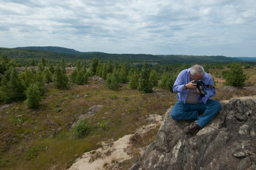 Fototapeta na wymiar hiker on top of mountain taking photograph