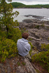 Man looking out to rocky shoreline