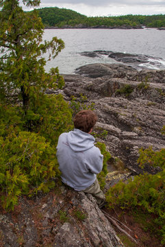 Man looking out to rocky shoreline