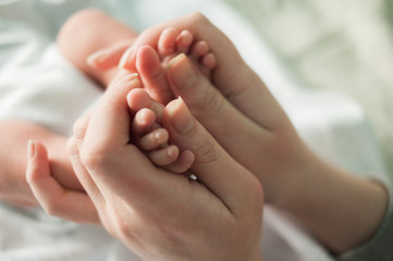 Obraz na płótnie Canvas baby feet in mother's hands