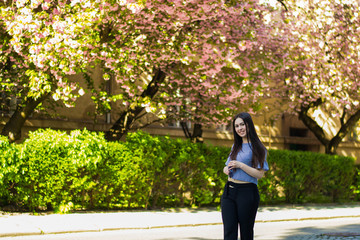 Plus size fashion model in casual clothes, overweight female body in a park outdoors. Spring concept.