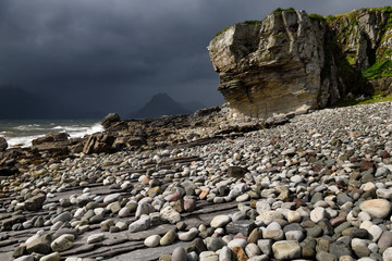 Smooth boulders of Elgol beach at Port na Cullaidh with Red Cuillin Mountains under clouds on Loch Scavaig Isle of Skye Scotland UK