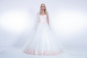 Naklejka premium Braut in weißem Brautkleid und Schleiher im Hellen strahlenden Licht Porträt