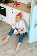 Woman holding a bottle of yogurt near the fridge