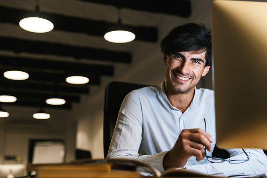 Smiling Young Man Working At The Office Late At Night