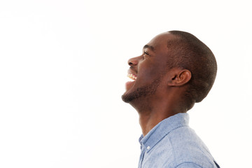 profile portrait of handsome young black man laughing against isolated white background