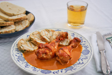Close up picture of traditional czech dish, chicken with sweet pepper or paprika creamy sauce with bread dumplings served on rustic plate with class of apple cider. Typical for czech or middle europe.