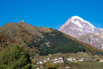 Mount Kazbek (Mkinvartsveri) and Gergeti church at sunny day. Caucasus mountains