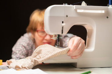 female tailor thread sewing machine on dark background