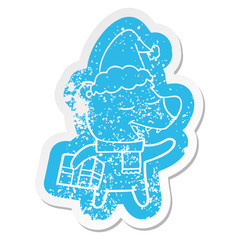 cartoon distressed sticker of a bear with present wearing santa hat