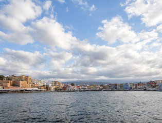 Fototapeta na wymiar The city of Chania is a port on the west coast of the Cretan Sea in Greece. A tourist attraction, a long quay, interesting architecture, a Turkish bath building, houses. Mountains on the horizon.