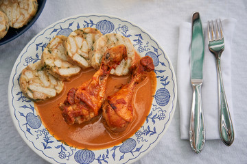 Top view picture of traditional czech dish, chicken with sweet pepper or paprika creamy sauce with bread dumplings served on rustic plate with class of apple cider. Typical for czech or middle europe.