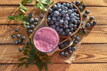 Fototapeta na wymiar Blueberries smoothie with fresh berry on rustic wooden background.Top view