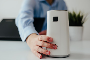 Ionizer stands on a white shelf on a white background. Air purifier at work, taking care of the...